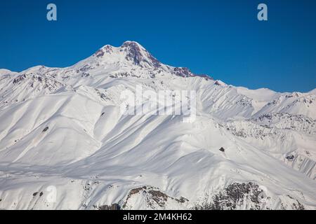 Le sommet du Mont Kazbek avec les montagnes du Caucase couvertes de neige, Gudauri Banque D'Images