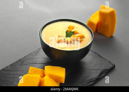 soupe à la crème de potiron, purée de pommes de terre sur fond gris. Purée de soupe de lentilles de potiron au curry vegan dans un bol. Espace pour le texte. Manger des Pescatariens Banque D'Images