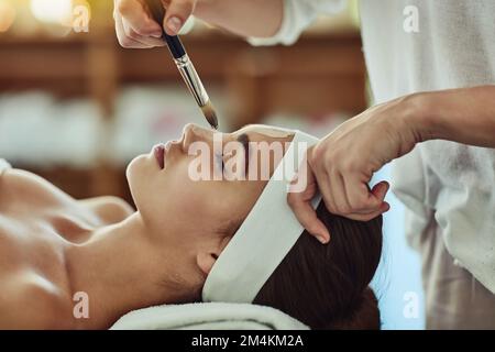 Prenez une journée pour améliorer votre peau. une jeune femme attirante se faisant un soin du visage dans un spa de beauté. Banque D'Images