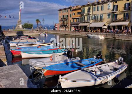 Lazise: Port de pêche et marina avec des bateaux amarrés et des restaurants à Lazise sur le lac (Lago) Garda, Vérone, Vénétie, Italie Banque D'Images