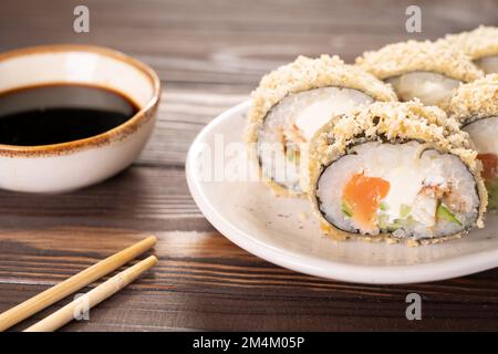 Roulés de sushis frits chauds avec saumon, avocat et fromage philadelphie. Menu sushi. Cuisine japonaise. Futomaki Banque D'Images