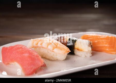 Sushi nigiri de fruits de mer sur l'assiette. Différents en-cas gastronomiques. La nourriture est chère, le menu du restaurant. Cuisine japonaise traditionnelle, fruits de mer savoureux, resta Banque D'Images