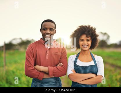 Quand vous le savez, vous le savez. Portrait court d'un jeune couple de ferme debout avec leurs bras pliés. Banque D'Images