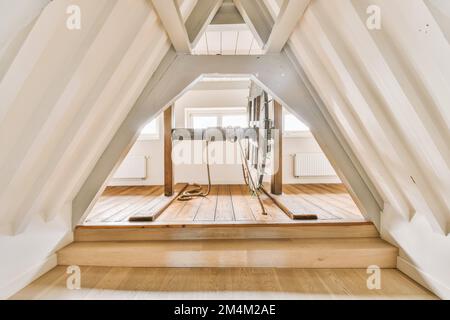 l'intérieur d'une chambre avec parquet et peinture blanche sur les murs, dans une maison de style grenier Banque D'Images