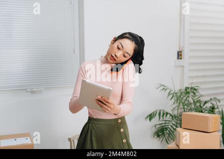 Les hommes d'affaires asiatiques acceptent les commandes en ligne par téléphone Banque D'Images