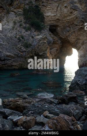 Mer entourée de rochers baie de Delikdeniz rayons d'or du soleil Kings Bay et ruines anciennes dans le trou de roche de la mer de Turquie Banque D'Images