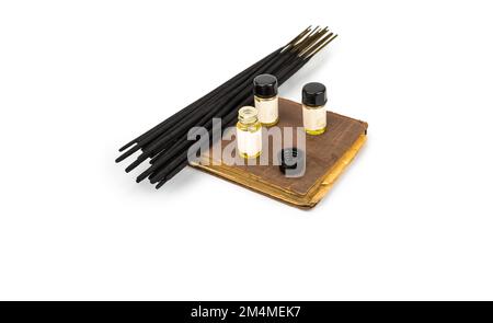 Bâtons d'Encens sur un livre vintage avec des bouteilles de parfum Banque D'Images