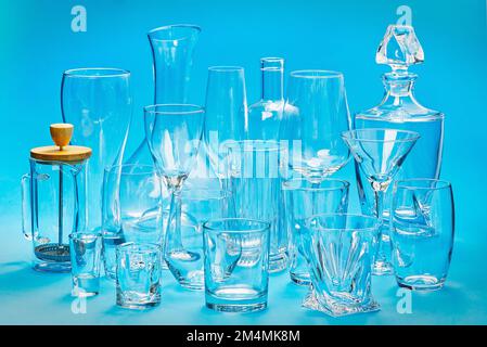 Jeu de différents verres vides sur fond bleu Banque D'Images