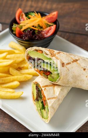 Les végétariens emballez les frites avec les légumes sur une assiette en porcelaine blanche Banque D'Images