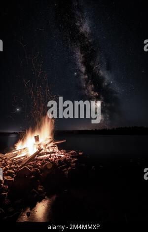 Une vue panoramique d'un feu brûlant sous la nuit étoilée en Finlande Banque D'Images
