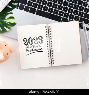 Budget financier annuel et plan d'économie concept avec ordinateur portable, banque de porc, calculatrice et bloc-notes avec espace de copie sur fond blanc de table. Banque D'Images