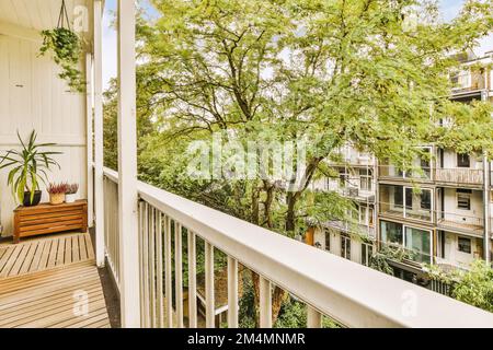 un espace extérieur avec des arbres et des plantes sur le côté d'une maison, pris d'un balcon donnant sur la rue Banque D'Images