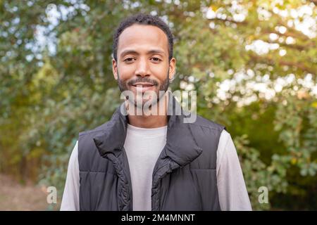 Portrait d'un homme afro-américain souriant, plein de confiance et de joie à l'appareil photo. Banque D'Images