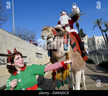 Jérusalem, Israël. 22nd décembre 2022. L'AISS Kassissieh, habillé comme le Père Noël, passe un chameau à l'extérieur de la vieille ville de Jérusalem, jeudi, 22 décembre 2022, quelques jours avant Noël. Photo de Debbie Hill/ Credit: UPI/Alay Live News Banque D'Images