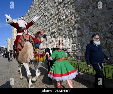 Jérusalem, Israël. 22nd décembre 2022. L'AISS Kassissieh, habillé comme le Père Noël, passe un chameau à l'extérieur de la vieille ville de Jérusalem, jeudi, 22 décembre 2022, quelques jours avant Noël. Photo de Debbie Hill/ Credit: UPI/Alay Live News Banque D'Images