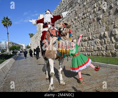 Jérusalem, Israël. 22nd décembre 2022. L'AISS Kassissieh, habillé comme le Père Noël, passe un chameau à l'extérieur de la vieille ville de Jérusalem, jeudi, 22 décembre 2022, quelques jours avant Noël. Photo de Debbie Hill/ Credit: UPI/Alay Live News Banque D'Images