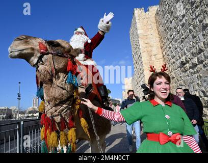 Jérusalem, Israël. 22nd décembre 2022. L'AISS Kassissieh, habillé comme le Père Noël, passe un chameau à l'extérieur de la vieille ville de Jérusalem, jeudi, 22 décembre 2022, quelques jours avant Noël. Photo de Debbie Hill/ Credit: UPI/Alay Live News Banque D'Images