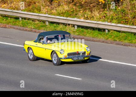 1975 70s, soixante-dix Yellow MG B MGB, une voiture de sport à deux portes, fabriquée et commercialisée de 1962 à 1980 par la British Motor Corporation (BMC) 1798cc Petrol British sports Cabrio, sur l'autoroute M6 au Royaume-Uni Banque D'Images