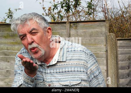 Homme âgé ou âgé qui soufflait un baiser. Dire Je t'aime. Banque D'Images