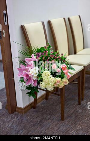Grand bouquet de fleurs colorées sur un fauteuil blanc. Jour de mariage. Banque D'Images