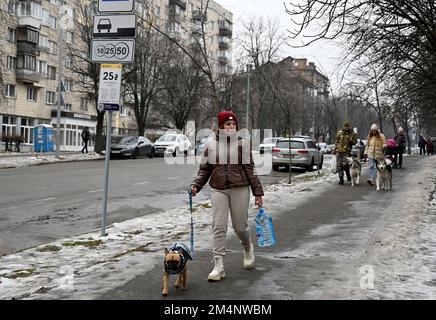 Kiev, Ukraine. 22nd décembre 2022. Une femme porte une bouteille d'eau en plastique lors d'une panne de courant à Kiev. L'armée russe a mené des attaques massives de roquettes et de drones kamikaze sur les infrastructures énergétiques ukrainiennes. Après de graves dommages au réseau électrique dans de nombreuses villes d'Ukraine, la compagnie nationale d'électricité Ukrenergo a introduit des coupures d'électricité d'urgence et toutes les heures. (Credit image: © Sergei Chuzavkov/SOPA Images via ZUMA Press Wire) Banque D'Images