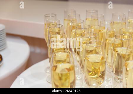 Verres élégants avec support à champagne frais dans la rangée. Beaucoup de verres avec champagne pendant sur la table de fête. Banque D'Images