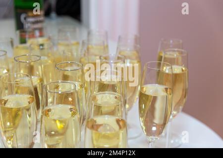 Verres élégants avec support à champagne frais dans la rangée. Beaucoup de verres avec champagne pendant sur la table de fête. Banque D'Images