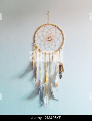 Vue verticale rapprochée d'un dreamcatcher suspendu à un mur blanc Banque D'Images