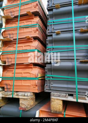 Neckargemuend, Allemagne: 7 octobre 2022: Des piles de tuiles de toiture rouges et anthracite attendent d'être traitées sur un chantier de construction Banque D'Images