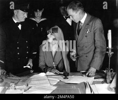 GRETA GARBO sur un décor franc avec des officiers et marins de la marine suédoise pendant le tournage de LA TEMPÊTE 1926 réalisateurs FRED NIBLO et MAURITZ STILLER (enlevé et remplacé) histoire Vicente Blasco Ibanez scénario Dorothy Farnum producteur Irving Thalberg Metro Goldwyn Mayer Banque D'Images