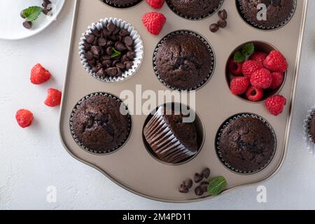 Muffins au chocolat faits maison dans un moule à muffins fraîchement cuit Banque D'Images