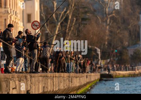istanbul , turquie - 23 février 2020 : groupe surpeuplé de personnes pêchant au bord de la mer à istanbul , pêcheurs alignés Banque D'Images