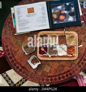 Différentes épices, mélanges d'épices dans des bols, livre de cuisine avec spécialités marocaines, cours de cuisine, Marrakech, Maroc Banque D'Images