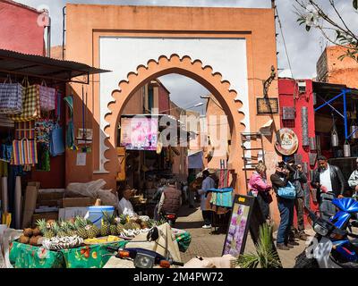 Portail orné dans le souk animé, boutiques colorées, stands, touristes et passants, médina, Patrimoine mondial de l'UNESCO, Marrakech, Maroc Banque D'Images