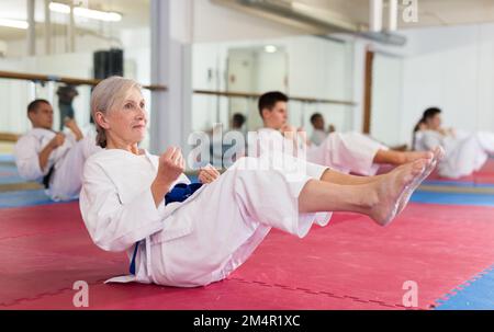 Athlètes homme et femme au kimono faire des exercices d'échauffement dans la salle de gym Banque D'Images