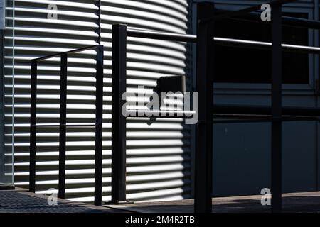 Une façade ondulée et une balustrade baignées de soleil forment un motif graphique. Banque D'Images