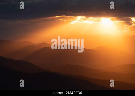 Des rayons crépusculaires dorés déversent et éclairent les montagnes et les vallées du parc national de Shenandoah. Banque D'Images