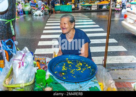Bangkok, Thaïlande - 12 mai 2009: Une femme âgée vend des fleurs saintes orange aux habitants de la région au marché de nuit Pak khlong Talat dans Chinatown, Bangko Banque D'Images
