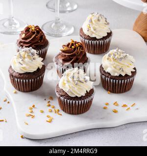 Petits gâteaux festifs avec saupoudrer servis avec du champagne pour la fête de la Saint-Sylvestre, idée de dessert Banque D'Images