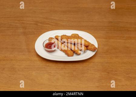 Une portion de poulet croustillant sur un plateau en porcelaine blanche avec un bol en verre de sauce Banque D'Images