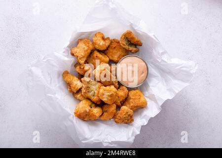 Nuggets de poisson-chat frits servis avec une sauce remoulade sur une assiette de papier parchemin Banque D'Images