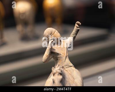 Un gros plan de la figurine d'argile blanche d'un homme d'Asie de l'est sur un fond flou Banque D'Images