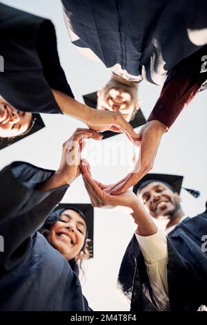 Nous voulons juste construire un monde meilleur. Gros plan d'un groupe d'élèves se joignant entre eux dans un cercle le jour de la remise des diplômes. Banque D'Images