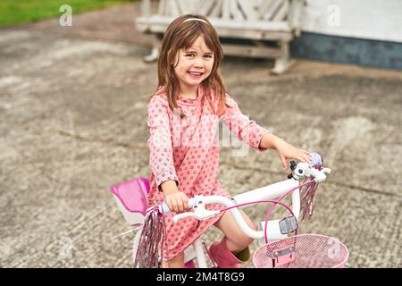 Cette princesse se rend à vélo. Portrait d'une adorable petite fille à vélo à l'extérieur. Banque D'Images