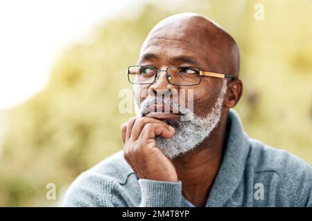 Je pense beaucoup quand je suis en plein air... un homme de haut niveau qui a l'air attentif quand il est assis dehors. Banque D'Images
