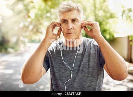 La musique fait disparaître tout le reste. un homme mûr pour sa course du matin. Banque D'Images