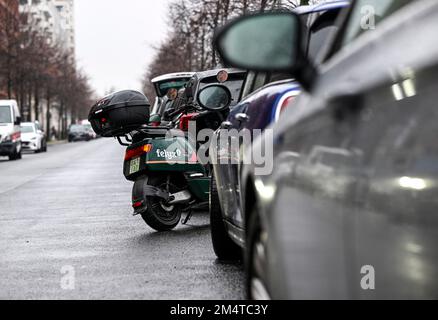 Berlin, Allemagne. 22nd décembre 2022. Un e-scooter est stationné sans prudence dans une place de stationnement sur la route. La partie arrière dépasse sur la chaussée. Credit: Jens Kalaene/dpa/Alamy Live News Banque D'Images