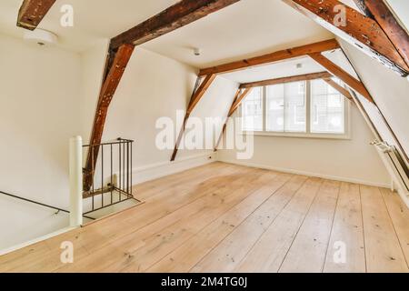 une chambre de style grenier avec parquet et poutres apparentes au plafond dans cette maison est très bien meublée Banque D'Images