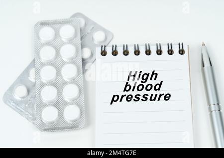 Concept médical. Sur une surface blanche sont des pilules dans un paquet, un stylo et un bloc-notes avec l'inscription - hypertension Banque D'Images