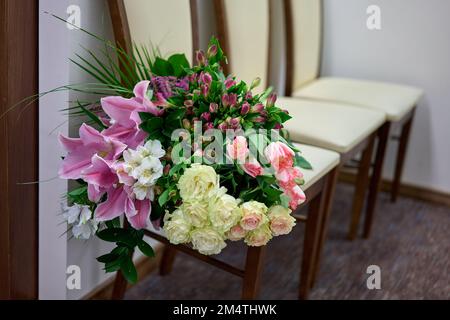Grand bouquet de fleurs colorées sur un fauteuil blanc. Jour de mariage. Banque D'Images